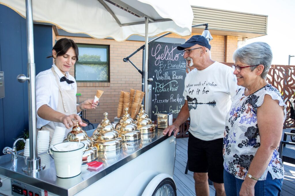A couple waiting for a gelato at a gelato cart